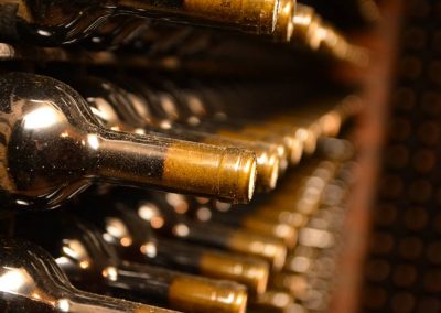 Slika flaša vina na polici sa zlatnim vrhovima